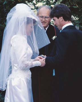 Photo d’une mariée passant l’alliance au doigt du marié